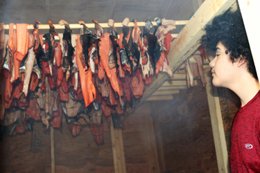 Hanging salmon in the smokehouse. Youth made half-dried salmon and t’los, a fish jerky. Photo credit: Brenda Bouzane.